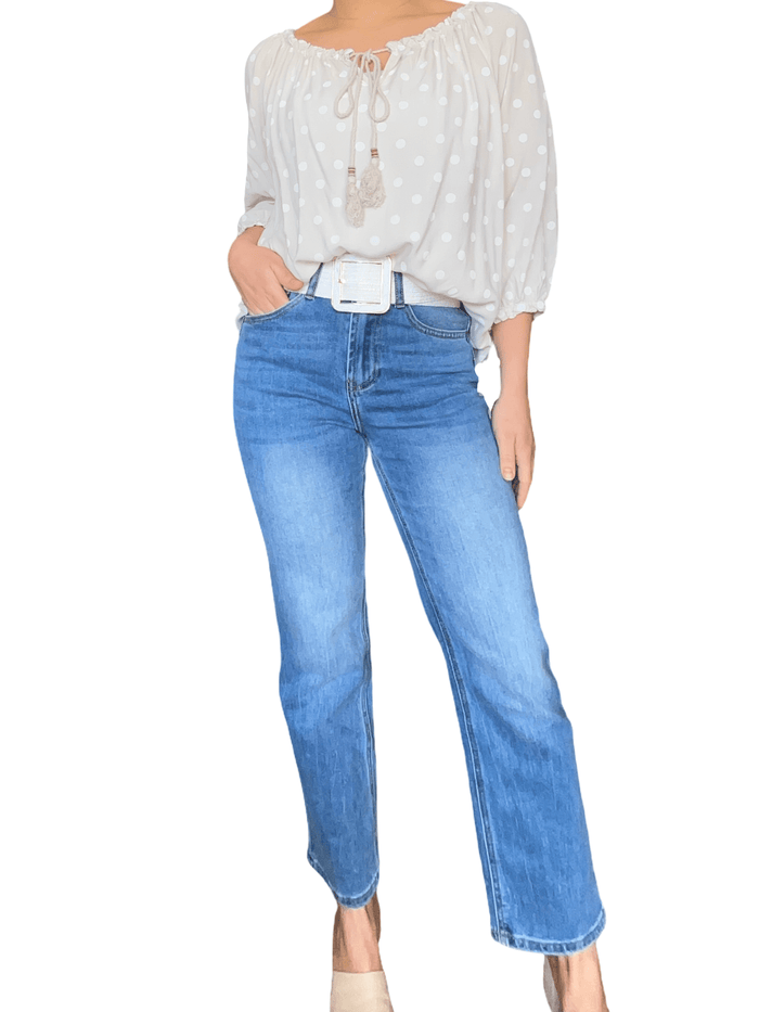 Blouse beige à motifs de pois blancs pour femme avec jeans.
