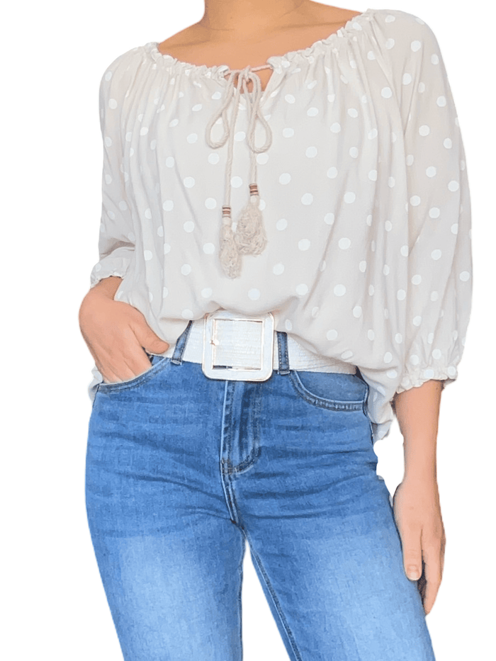Blouse beige à motifs de pois blancs pour femme avec ceinture blanche.