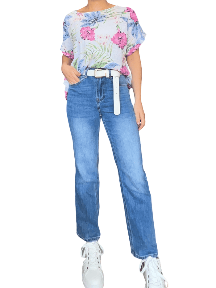T-shirt blanc avec imprimé floral fuchsia et bleu pour femme avec jeans et sneakers.