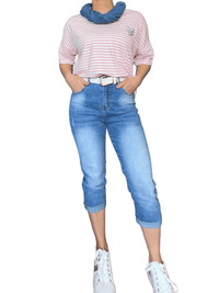 T-shirt blanc rayé rose pour femme avec capri et sneakers.