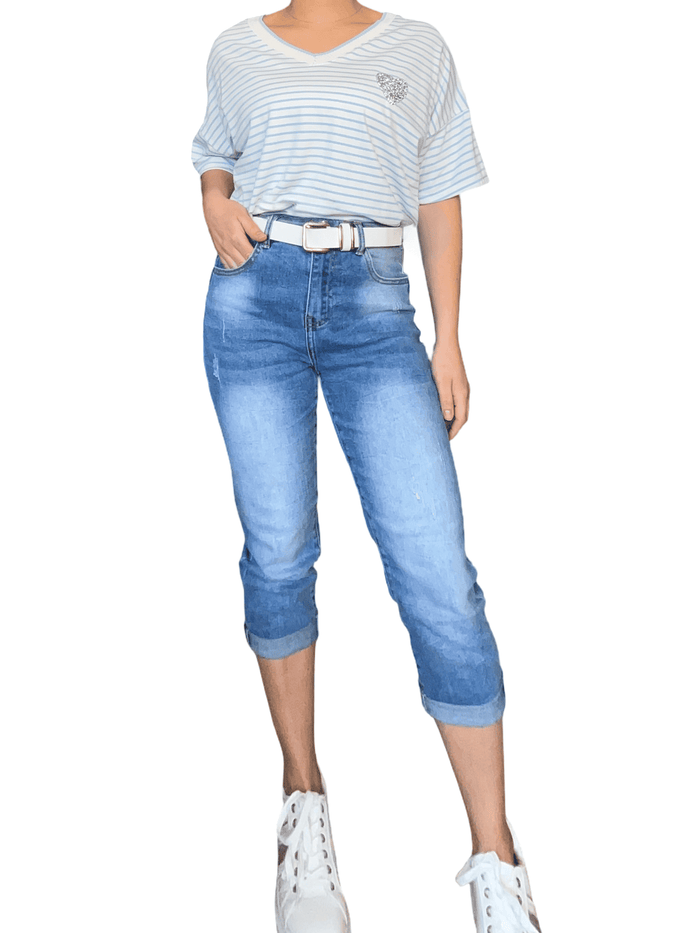 T-shirt blanc rayé bleu pour femme avec capri et sneakers.