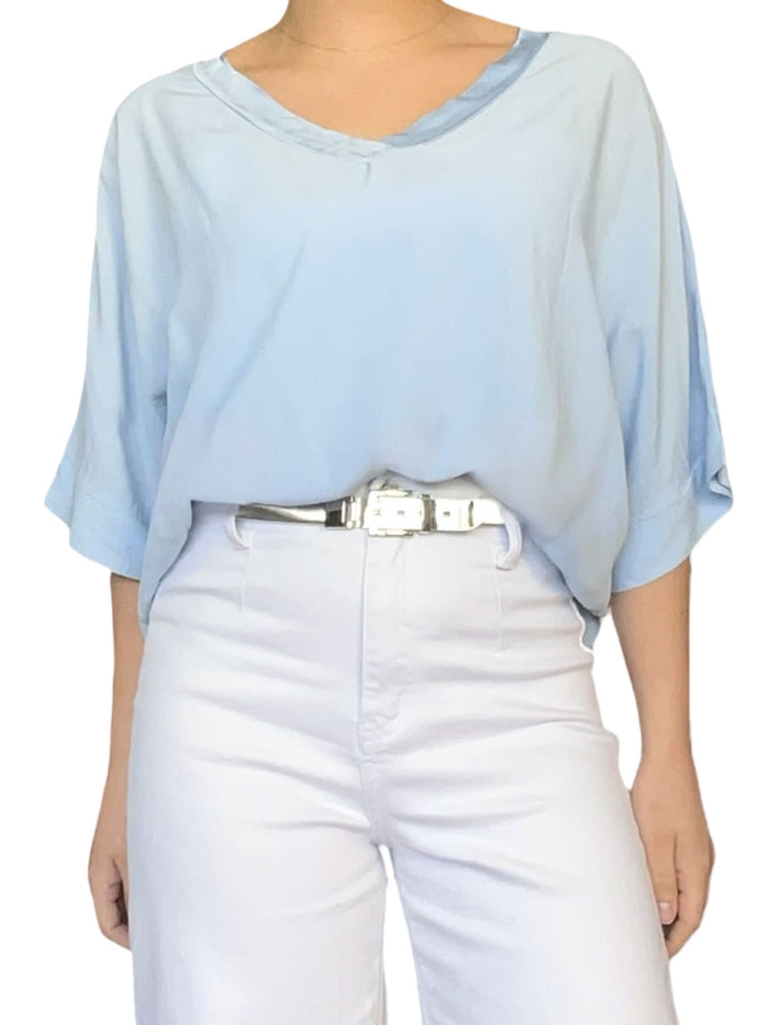 Chandail bleu ciel à manches courtes pour femme avec ceinture métallique.