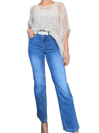 Chandail beige bohème en crochet pour femme avec jeans.