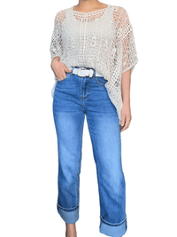 Chandail beige bohème en crochet pour femme avec jeans pliés dans le bas.
