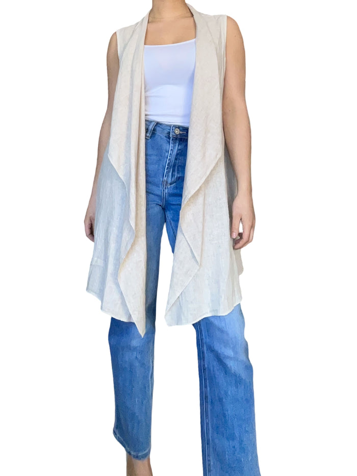 cardigan long beige sans manches pour femme avec jeans.
