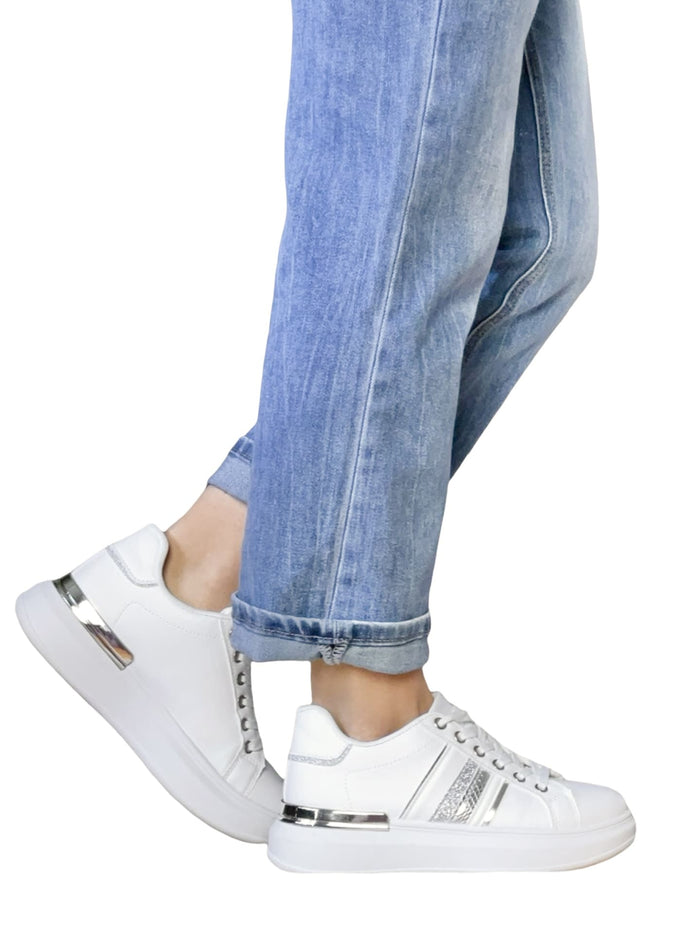 Sneaker blanc à plateforme avec détails argentés pour femme avec jeans.