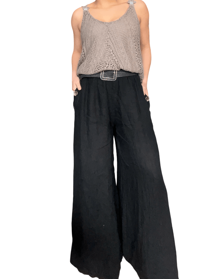 Pantalon palazzo noir avec boutons sur les côtés pour femme avec ceinture et camisole.