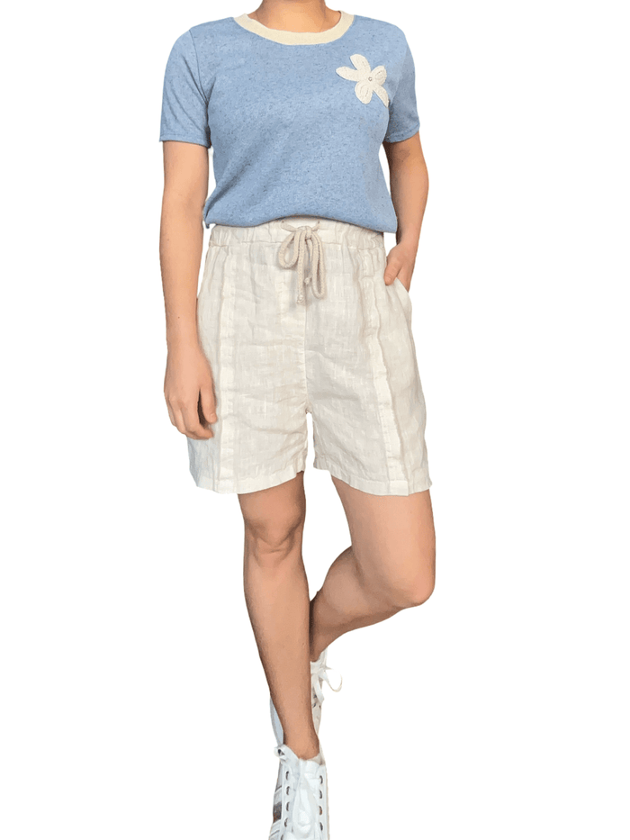 Short beige en lin à taille élastique avec cordon pour femme avec t-shirt.