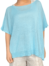 Chandail bleu ciel en mailles pour femme avec short et souliers.