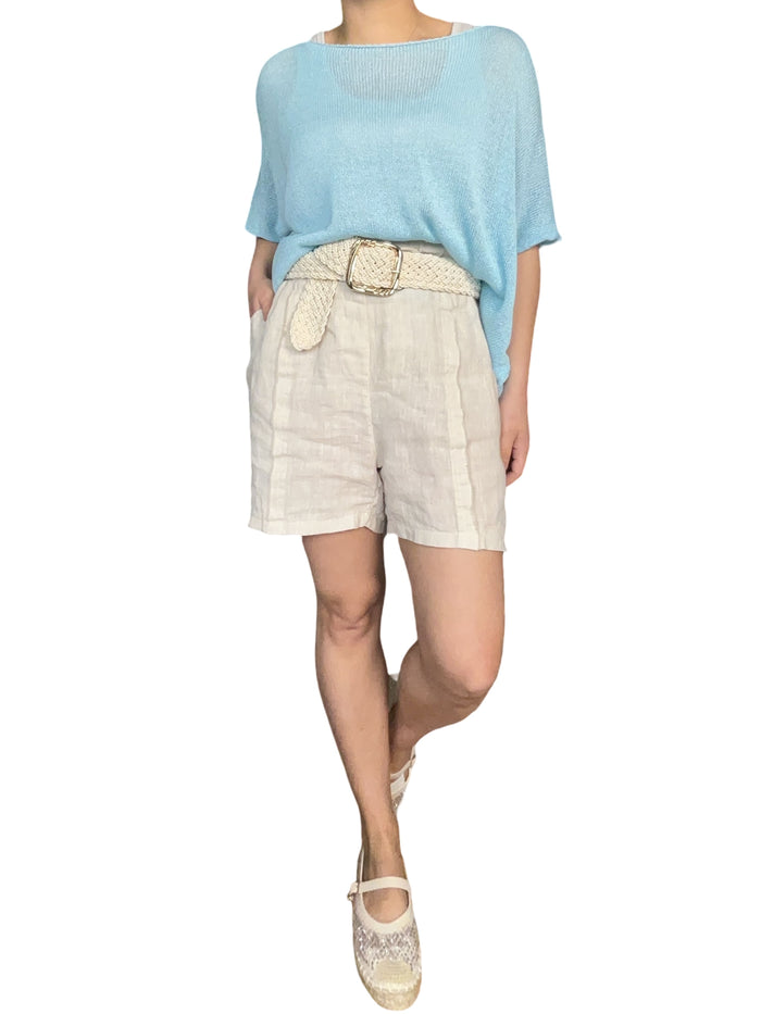 Chandail bleu ciel en mailles pour femme avec short et souliers.