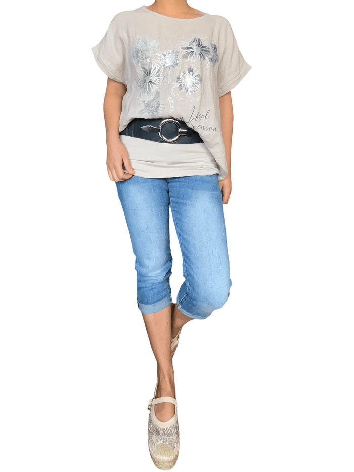 T-shirt beige pour femme avec imprimé floral argenté et blanc avec capri et souliers.