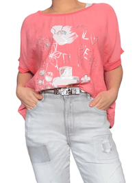 T-shirt corail avec imprimé floral blanc pour femme avec ceinture métallique.