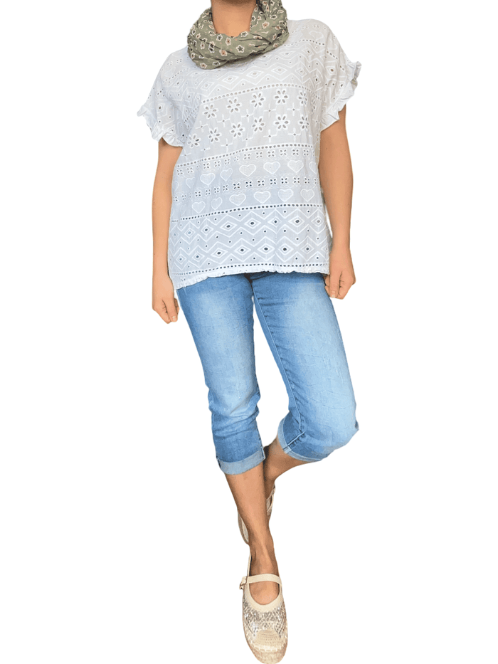 T-shirt blanc avec broderie anglaise pour femme avec capri et souliers.