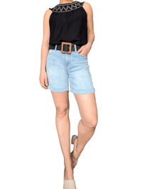 Short de jeans bleu pâle pour femme avec ceinture et camisole.