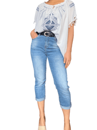 Blouse blanche avec imprimé bleu royal pour femme avec capri de jeans.