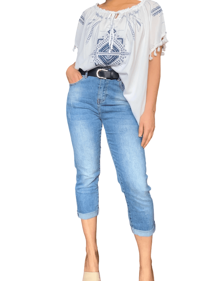 Blouse blanche avec imprimé bleu royal pour femme avec capri de jeans.