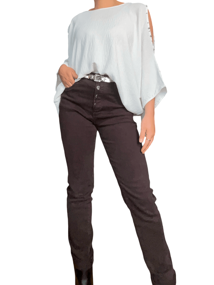 Blouse blanche à ouverture sur l'épaule pour femme avec pantalon.