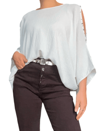 Blouse blanche à ouverture sur l'épaule pour femme avec ceinture métallique. 