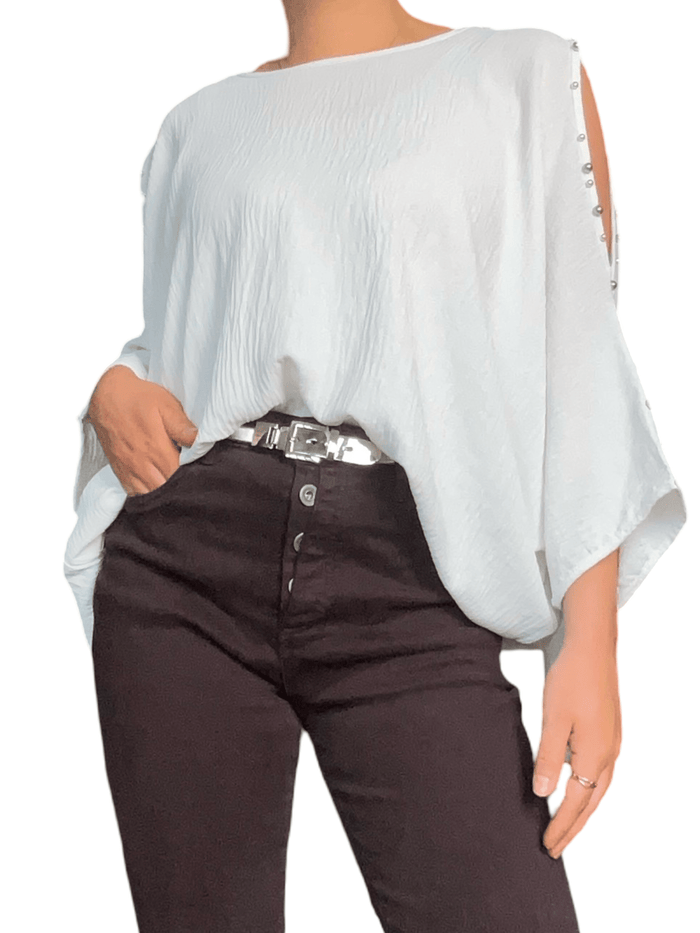 Blouse blanche à ouverture sur l'épaule pour femme avec ceinture métallique. 