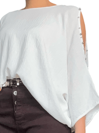 Blouse blanche à ouverture sur l'épaule pour femme.