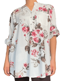 Blouse blanche avec imprimé de fleurs rouges pour femme.