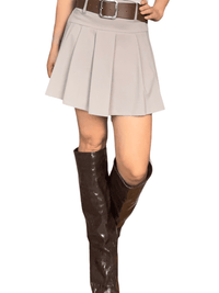 Jupe plissée beige avec ceinture pour femme avec bottes.