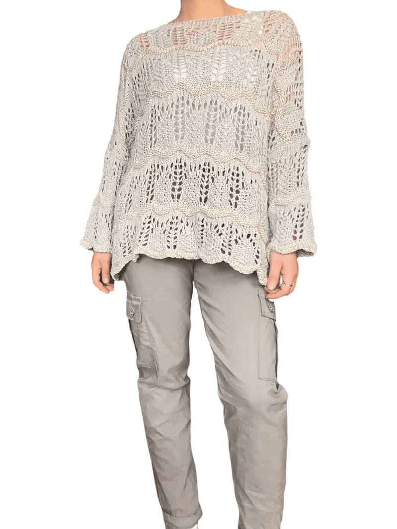 Chandail moka en tricot à rayures dorées avec camisole blanche en dessous.