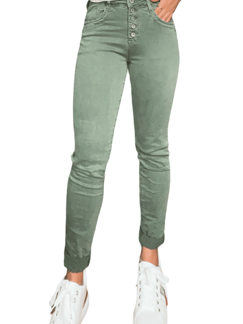 Jeans skinny kaki pour femme avec sneakers.
