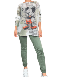 Chandail en mailles blanc et kaki avec imprimé de Mickey pour femme avec jeans et sneakers.