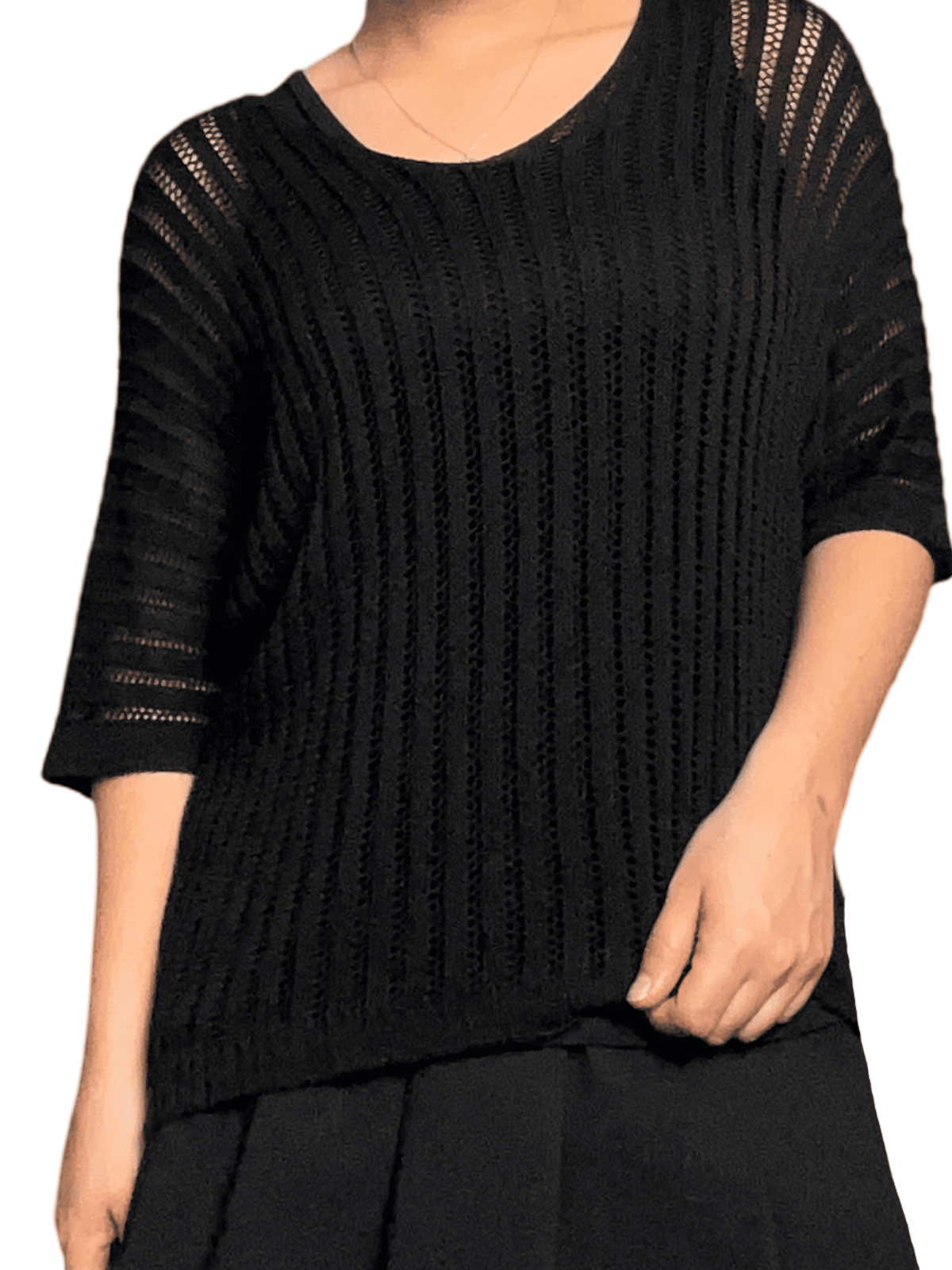 Chandail noir mince en mailles pour femme avec camisole noire en dessous.