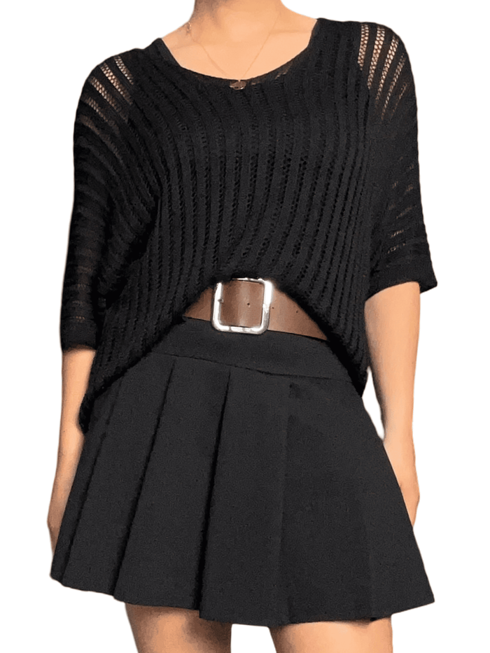 Chandail noir mince en mailles pour femme avec jupe et ceinture.