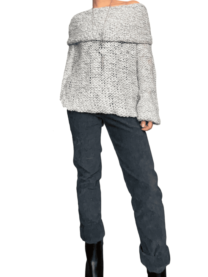 Chandail gris et blanc en crochet à col asymétrique pour femme avec pantalon et bottillons.