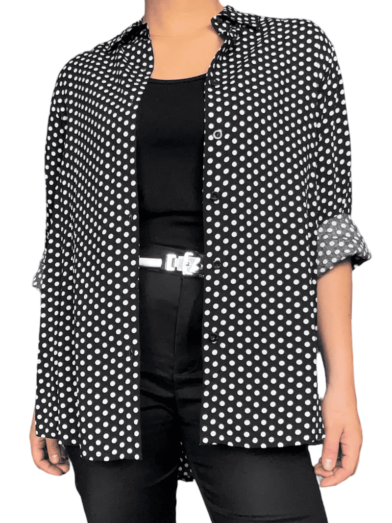 Chemise noire à motifs de pois blancs pour femme avec camisole noire en dessous.