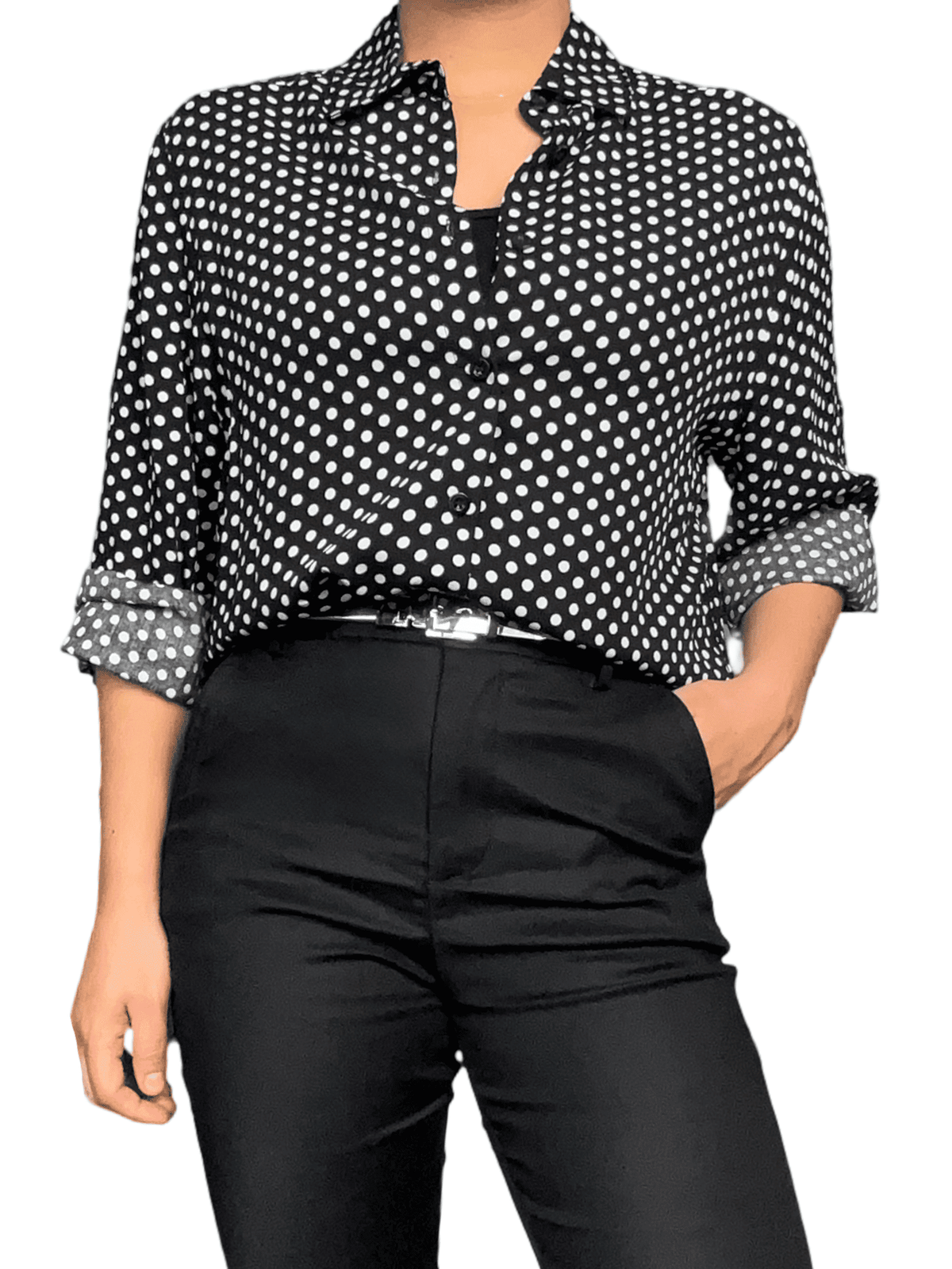 Chemise noire à motifs de pois blancs pour femme avec ceinture argentée.