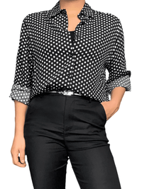 Chemise noire à motifs de pois blancs pour femme avec ceinture argentée.