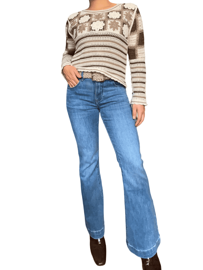 Chandail beige en tricot à motifs floraux pour femme avec jeans.