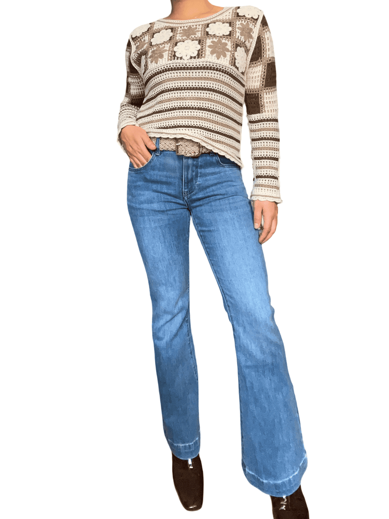 Chandail beige en tricot à motifs floraux pour femme avec jeans.