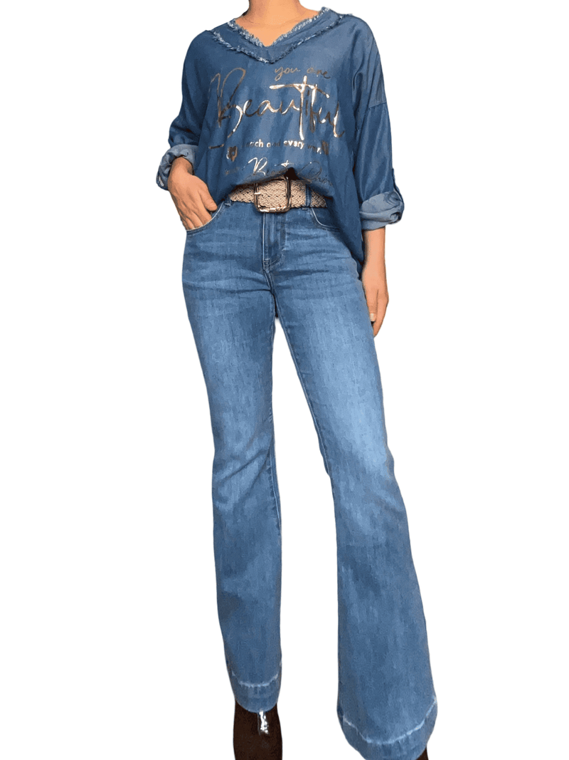 Chandail bleu jean avec franges pour femme avec jeans.