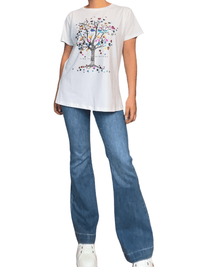 T-shirt blanc avec imprimé d'arbre et cœurs pour femme avec sneakers.