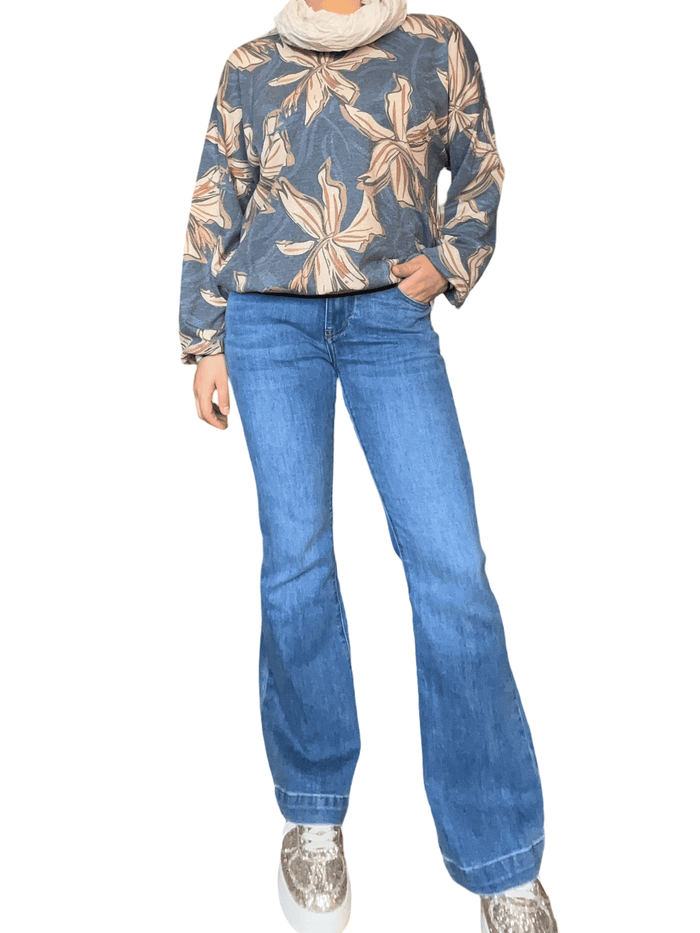 Chandail bleu jean avec imprimé floral et brillance pour femme avec foulard, jeans et sneakers.