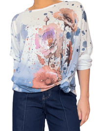 Chandail blanc crème avec imprimé abstrait et fleurs pour femme avec nœud sur le côté.