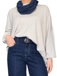 Chandail beige uni à manche longue pour femme avec foulard.