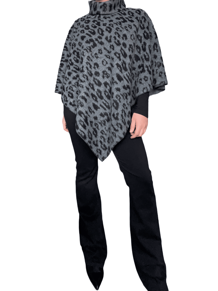 Jeans flare noir uni pour femme avec chandail et poncho.
