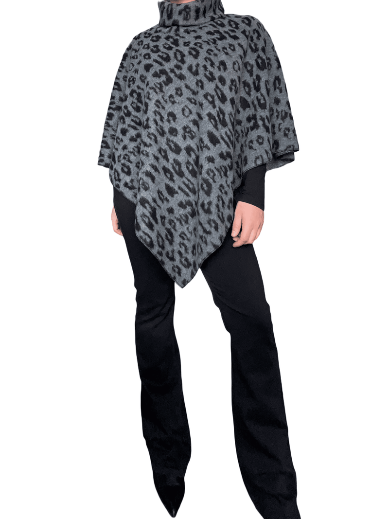 Jeans flare noir uni pour femme avec chandail et poncho.