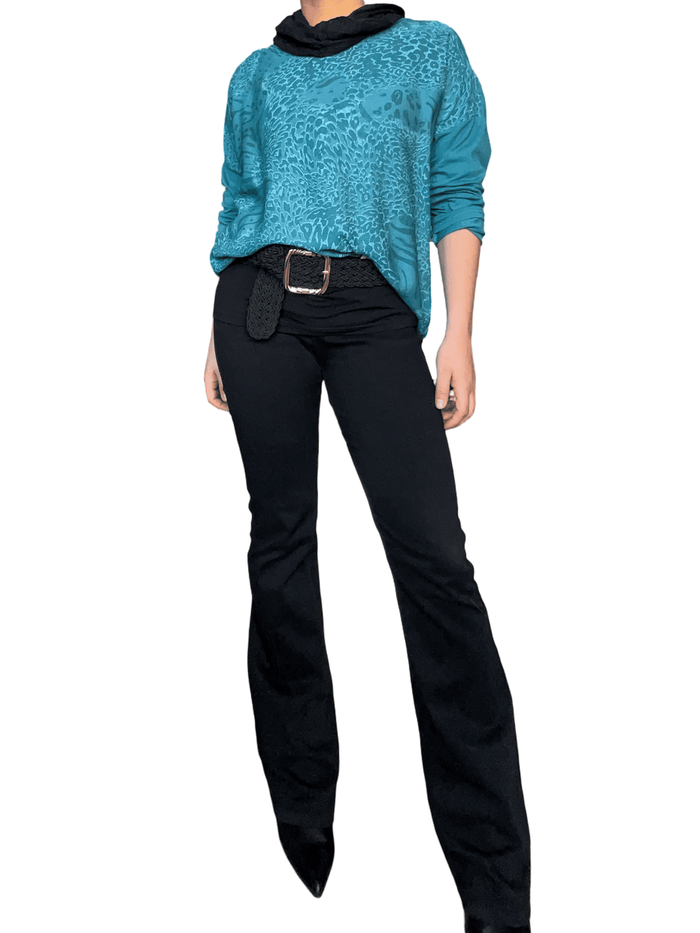 Chandail turquoise avec imprimé animal pour femme avec jean noir et bottillons.