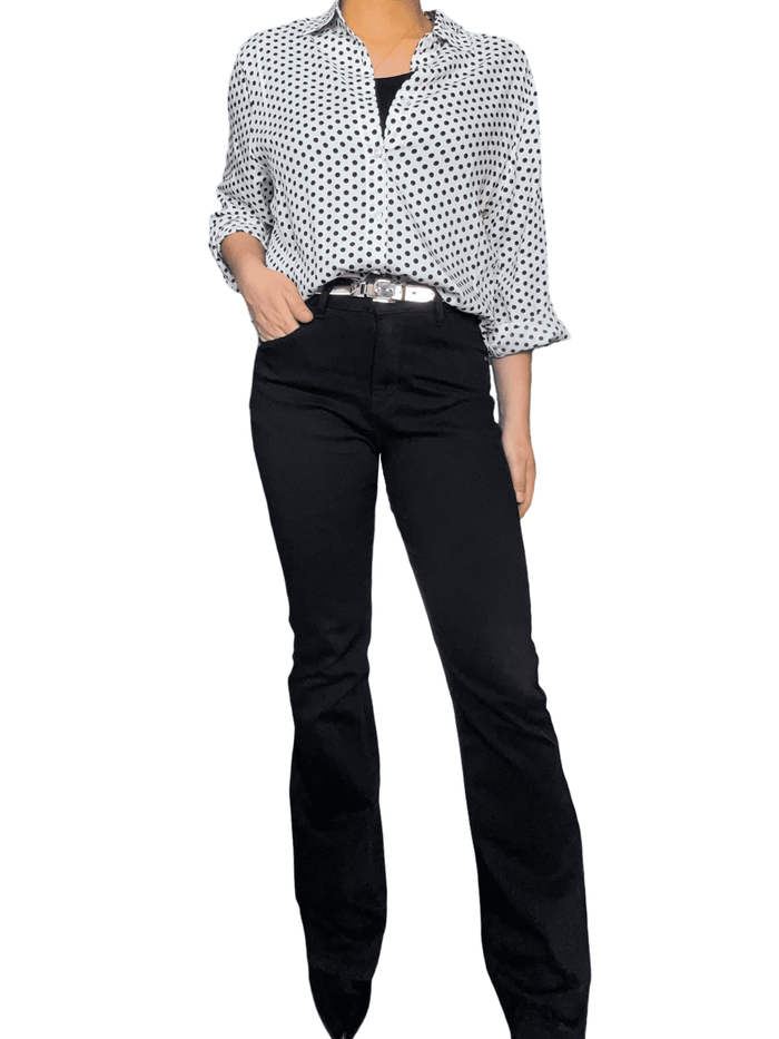 Chemise blanche à motifs de pois noirs pour femme avec pantalon noir.