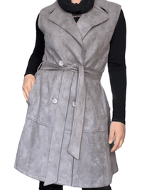 Veste trench gris sans manche pour femme avec foulard noir mince.