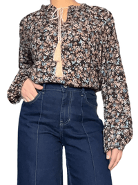 Blouse noire à motifs floraux marron & bleus pour femme avec jeans.