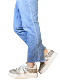 Sneaker beige à paillettes pour femme avec jeans.