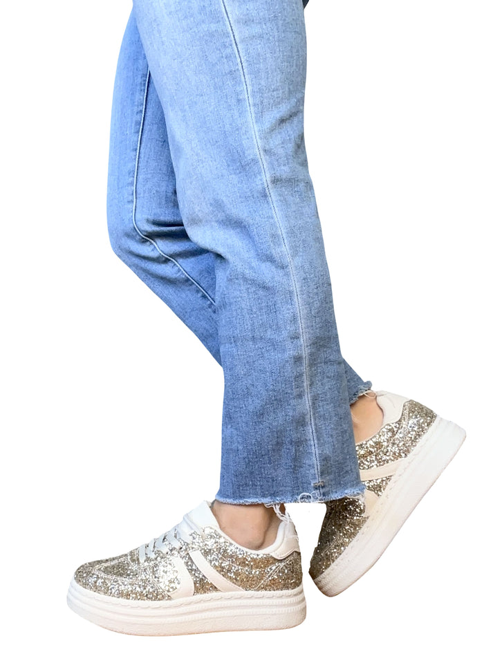 Sneaker beige à paillettes pour femme avec jeans.